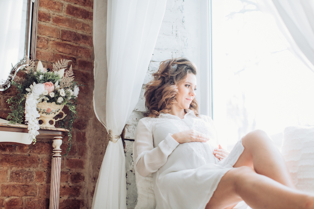 Pregnant Woman Posing In White Dress